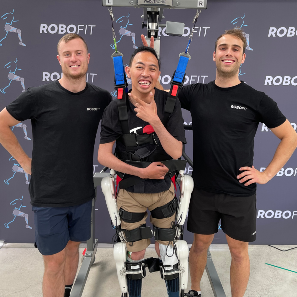 RoboFit therapists standing with a client who is wearing a neuro controlled exoskeleton